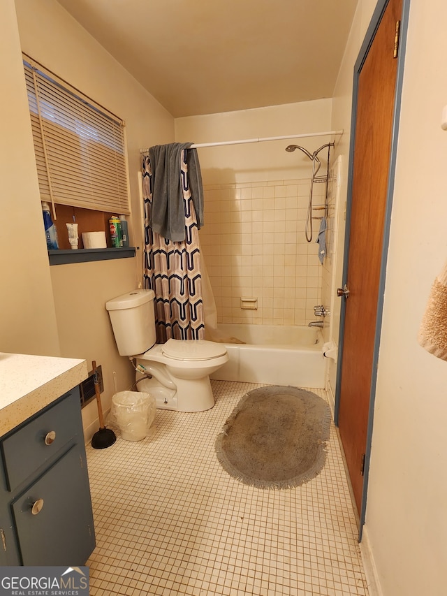 full bathroom featuring tile patterned floors, shower / bath combo with shower curtain, vanity, and toilet