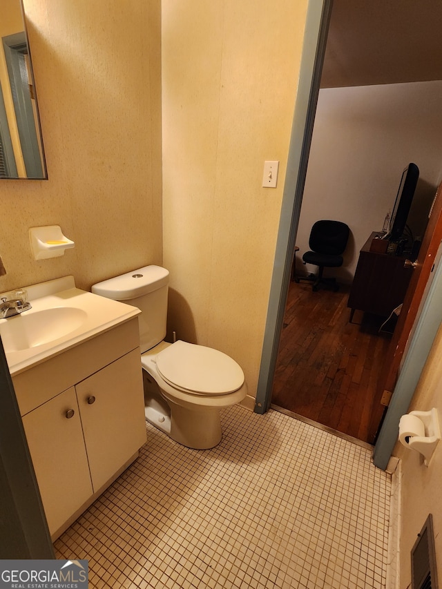 bathroom with hardwood / wood-style flooring, vanity, and toilet