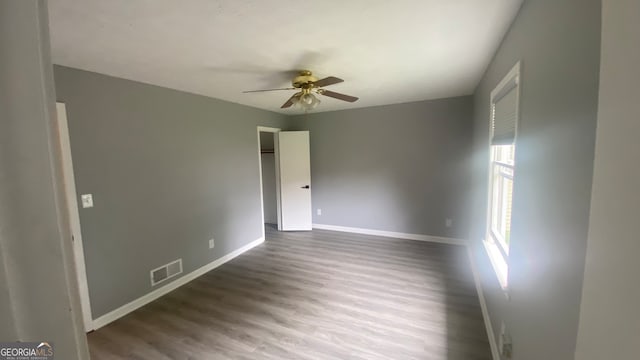 empty room featuring ceiling fan and dark wood-type flooring