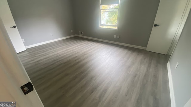 empty room with dark hardwood / wood-style flooring