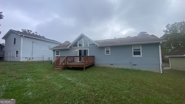 rear view of house featuring a wooden deck and a yard