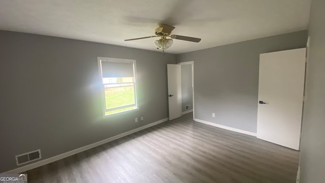 spare room featuring dark hardwood / wood-style flooring and ceiling fan