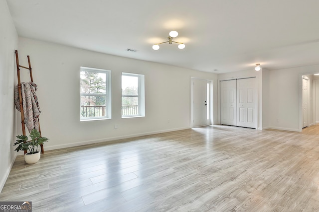 empty room with a barn door and light wood-type flooring