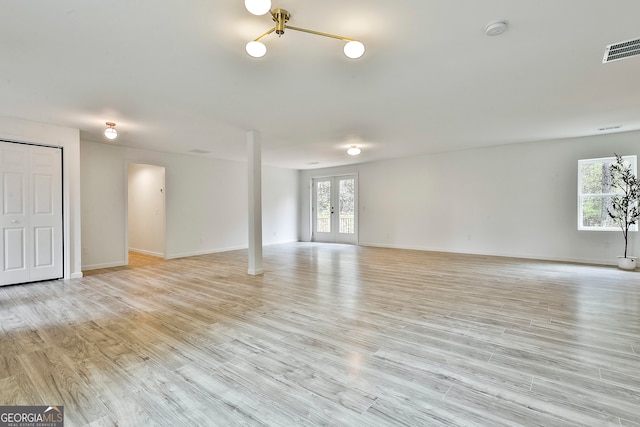 unfurnished room featuring french doors and light wood-type flooring