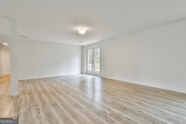 unfurnished room featuring french doors and light hardwood / wood-style flooring