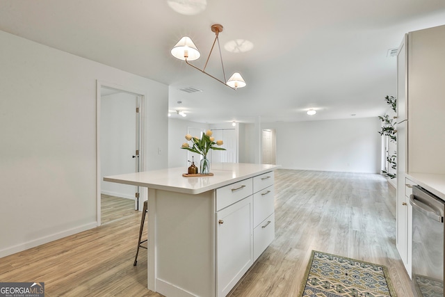 kitchen featuring pendant lighting, dishwasher, white cabinets, light hardwood / wood-style floors, and a kitchen island