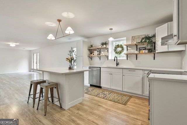 kitchen featuring white cabinets, dishwasher, sink, and decorative light fixtures