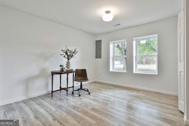 office with electric panel and light hardwood / wood-style floors