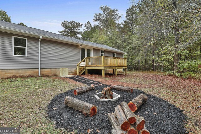 view of yard with a deck and an outdoor fire pit