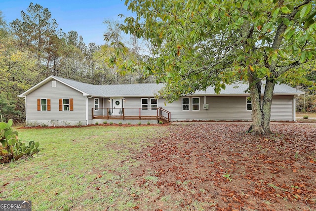 ranch-style home featuring a wooden deck and a front lawn