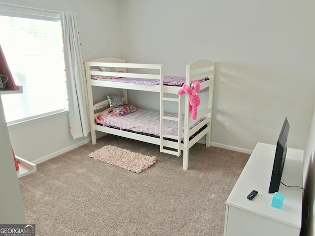 bedroom featuring light colored carpet and multiple windows