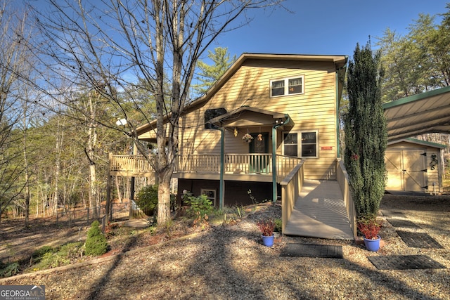 view of front facade featuring a wooden deck and a storage shed