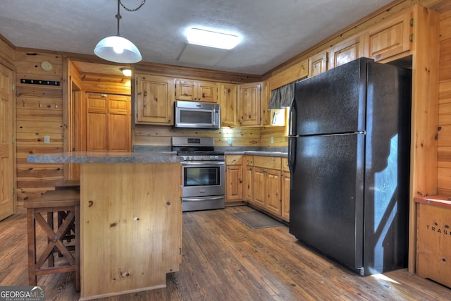 kitchen with a kitchen bar, a textured ceiling, stainless steel appliances, decorative light fixtures, and dark hardwood / wood-style floors