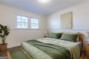 bedroom with crown molding and hardwood / wood-style floors