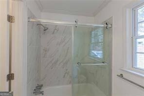 bathroom with ornamental molding, combined bath / shower with glass door, and a wealth of natural light