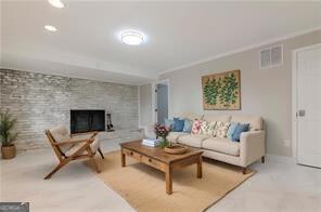 living room featuring crown molding and a fireplace