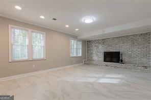 unfurnished living room with ornamental molding and a large fireplace