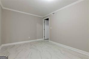 empty room featuring crown molding