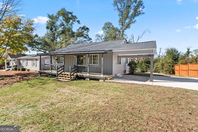 back of property with a porch, a carport, and a lawn