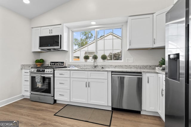 18 Watson Dr, Newnan, GA 30263 - kitchen with appliances with stainless steel finishes, a sink, white cabinetry, recessed lighting, and light stone countertops