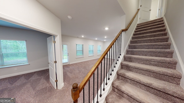 staircase featuring plenty of natural light and carpet floors