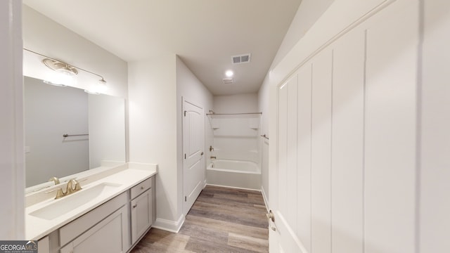 bathroom featuring hardwood / wood-style floors, vanity, and shower / bath combination