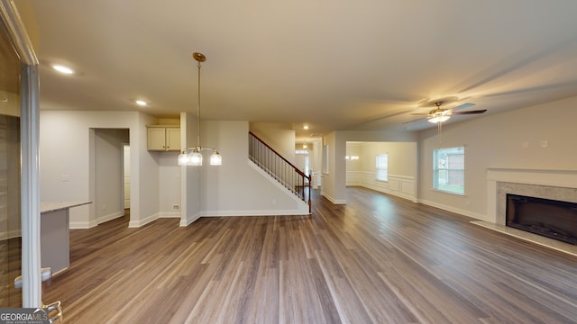 unfurnished living room featuring ceiling fan and dark hardwood / wood-style flooring