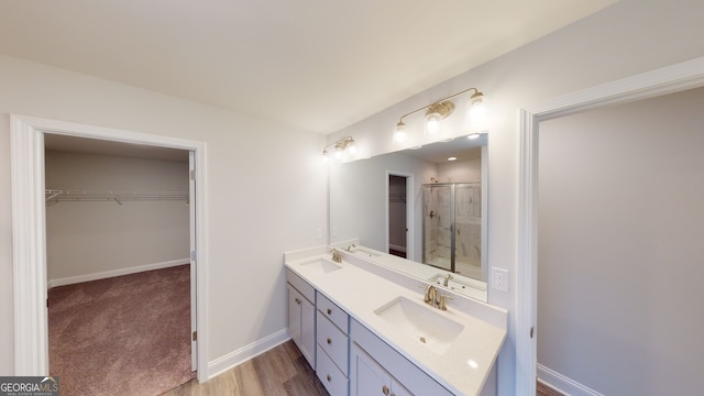 bathroom featuring wood-type flooring, vanity, and an enclosed shower