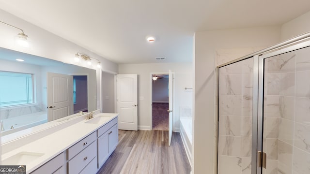 bathroom with vanity, separate shower and tub, and wood-type flooring