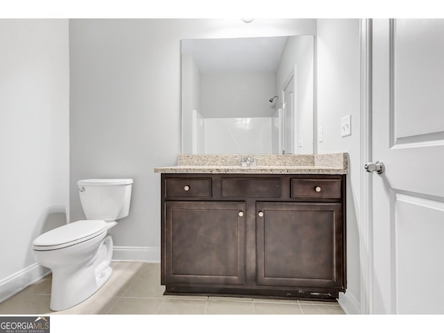 bathroom featuring toilet, a shower, vanity, and tile patterned floors