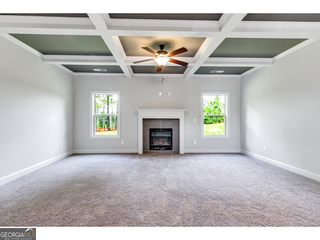 unfurnished living room featuring carpet, coffered ceiling, crown molding, a fireplace, and beam ceiling