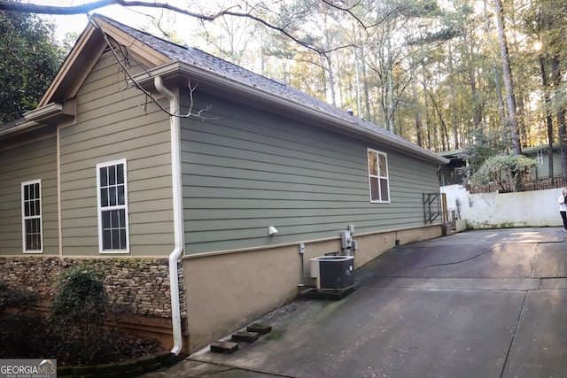 view of side of home with a patio and central AC unit