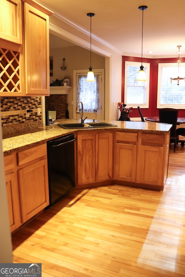 kitchen featuring black dishwasher, light hardwood / wood-style flooring, hanging light fixtures, and sink