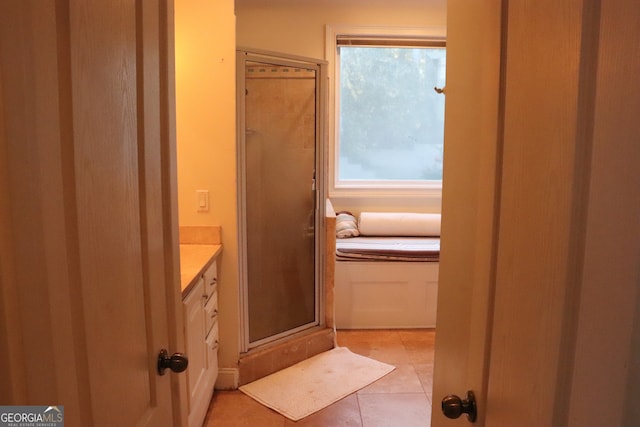 bathroom featuring tile patterned flooring, vanity, and an enclosed shower