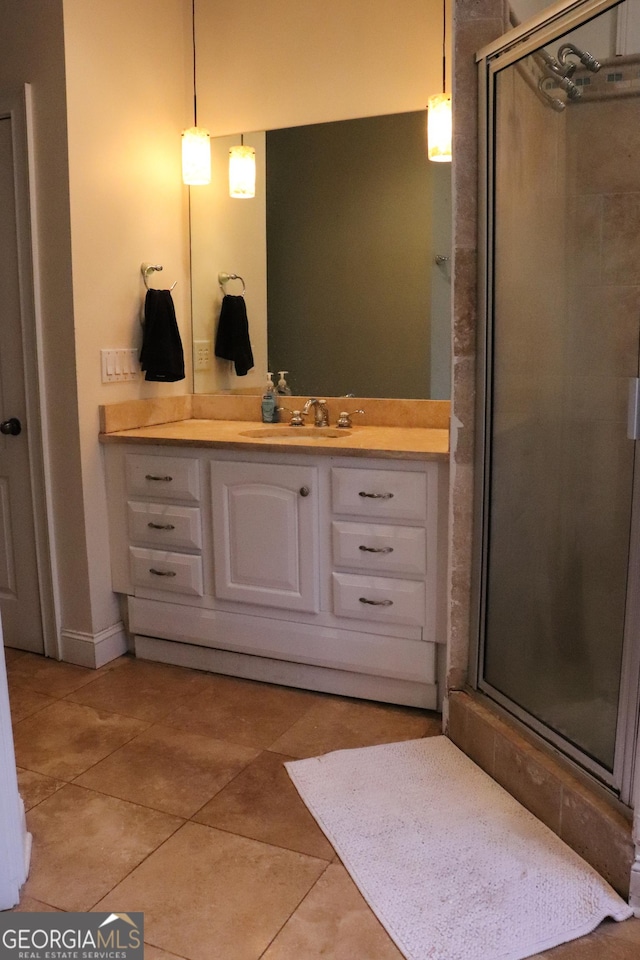 bathroom featuring tile patterned floors, vanity, and a shower with shower door