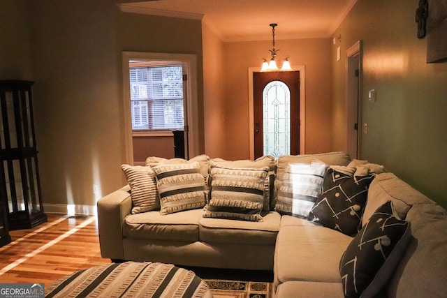 interior space with hardwood / wood-style flooring, ornamental molding, and an inviting chandelier