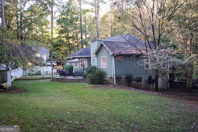 view of side of property with a yard and a deck