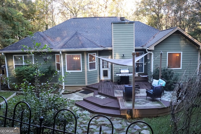 rear view of house featuring a wooden deck