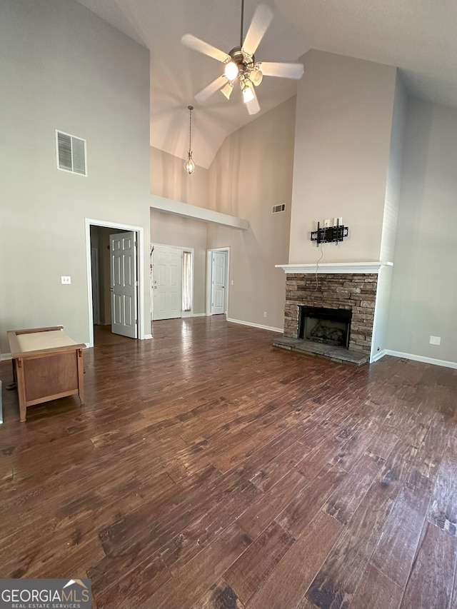 unfurnished living room with ceiling fan, a fireplace, high vaulted ceiling, and dark wood-type flooring