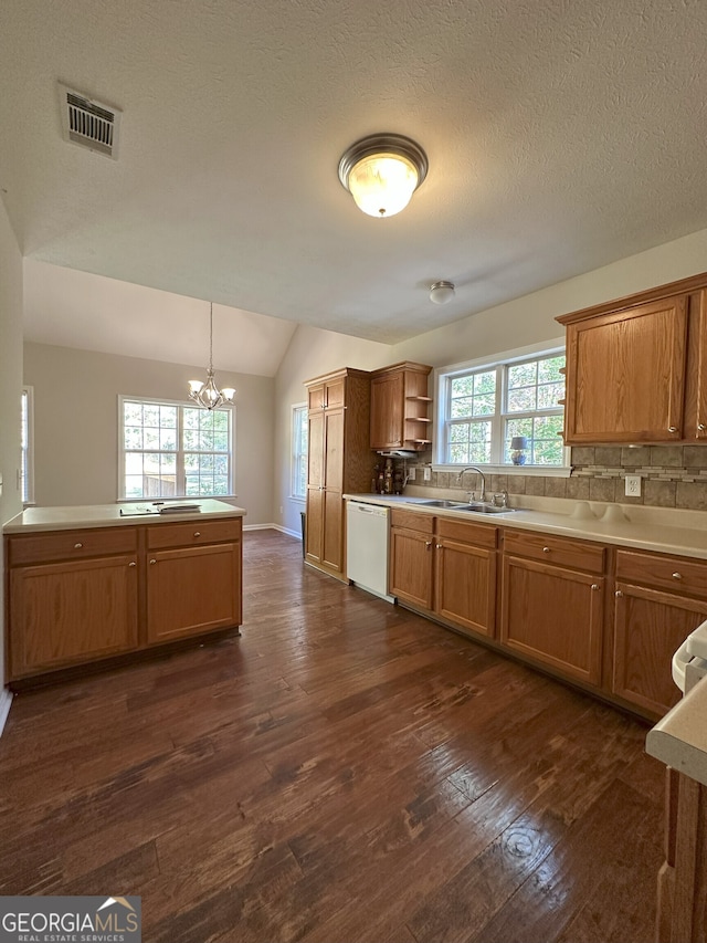 kitchen with lofted ceiling, dark hardwood / wood-style floors, a wealth of natural light, and a notable chandelier