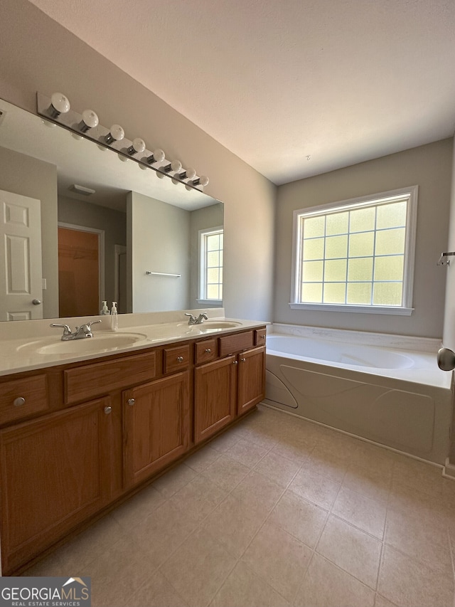 bathroom featuring a tub to relax in, tile patterned floors, and vanity