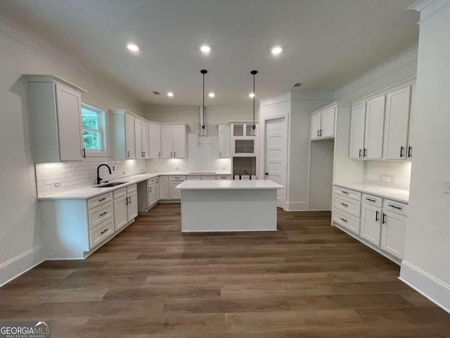 kitchen featuring white cabinetry, a center island, sink, dark wood-type flooring, and decorative light fixtures