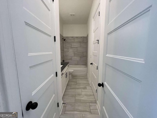 full bathroom with vanity, toilet, and tiled shower / bath