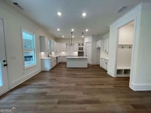 kitchen with dark hardwood / wood-style flooring, sink, white cabinets, a center island, and hanging light fixtures