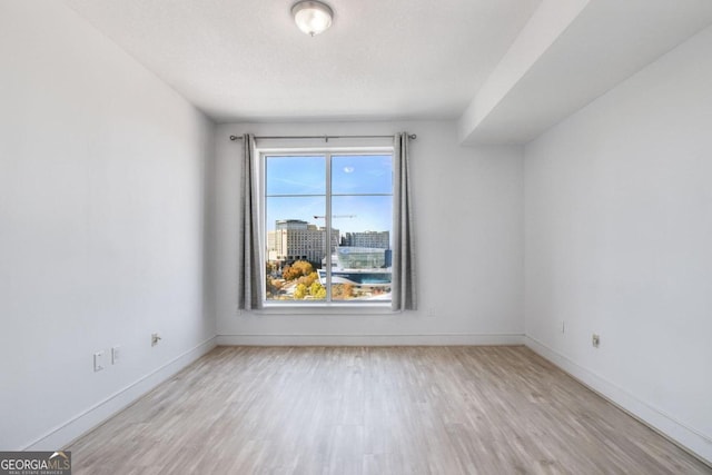 empty room featuring a textured ceiling and light hardwood / wood-style floors