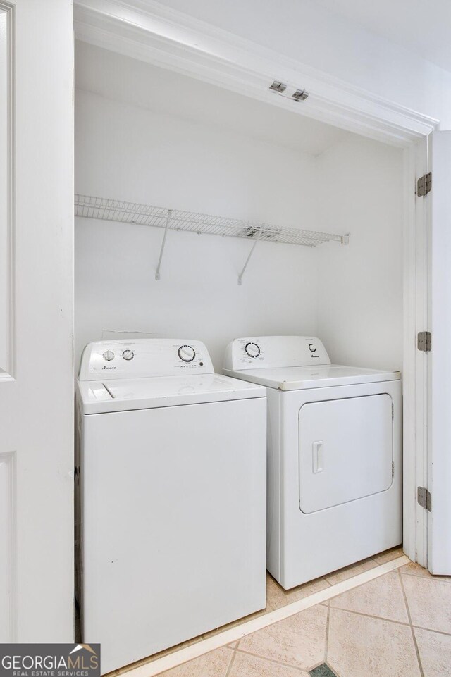 washroom with washer and dryer and light tile patterned flooring