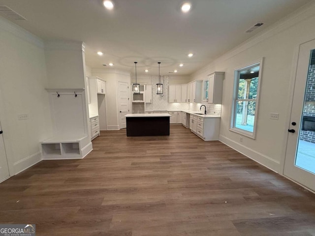 kitchen with white cabinetry, a center island, sink, dark hardwood / wood-style flooring, and pendant lighting