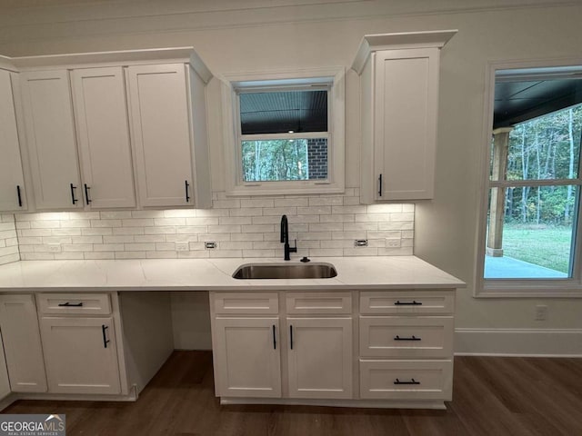 kitchen with dark hardwood / wood-style flooring, backsplash, white cabinetry, and sink