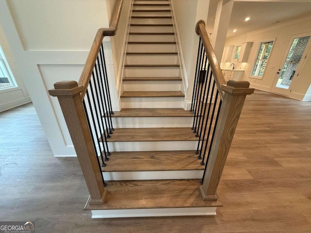 stairs with sink and hardwood / wood-style flooring