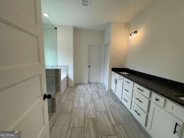 bathroom with vanity, a bath, and hardwood / wood-style flooring